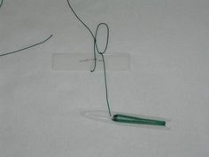 a pair of scissors and some string on a white sheet with a name tag attached to it