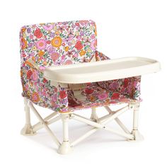 a baby high chair with floral fabric on it's back and seat cushion in the middle