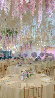 an elaborately decorated banquet hall with flowers hanging from the ceiling