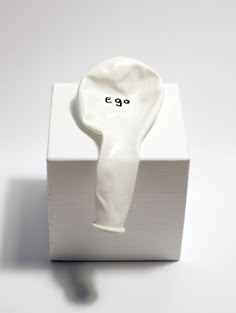 a white ceramic object with the word e g on it's side in black ink