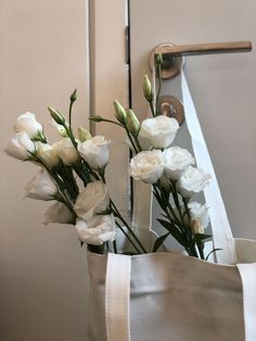 white flowers are sitting in a bag on the counter