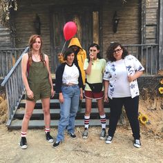 four women standing in front of an old house