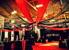 an event hall with red and black draping on the ceiling, decorated for a hollywood themed party