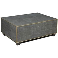 a grey ottoman with gold trim on top