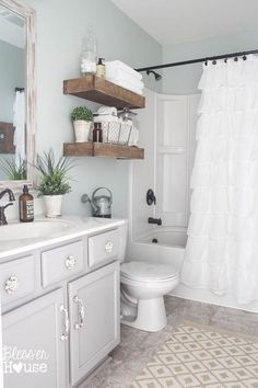 a bathroom with a white toilet sitting next to a bath tub under a mirror above a sink