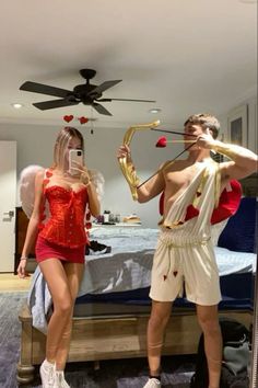 a man and woman dressed up in costumes standing next to each other on a bed