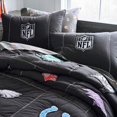 the nfl logo is on this comforter and pillow set in black with blue accents