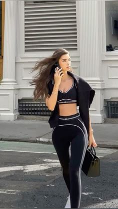 a woman walking down the street while talking on her cell phone