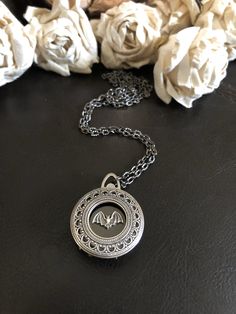 "🔸🔸orders are delayed by a few days this week. Thank you for your patience Family photo locket necklace, keepsake necklace This antiqued silver locket has been adorned with a bat charm which sets in an antiqued silver setting. This small folding spring locket is 1\" and can hold four small 3/4\" photos and hangs from 20\" of textured gunmetal chain and lobster clasp. You can also purchase additional chain by the inch for a longer necklace during checkout. I can also put this locket on a keycha Victorian Silver Locket Necklace Gift, Victorian Style Hallmarked Locket Necklace For Memorial, Victorian Adjustable Locket Necklace, Silver Gothic Locket Jewelry, Silver Victorian Locket Necklace For Memorial, Dragon Locket, Burlap Gift Bags, Bat Jewelry, Photo Locket Necklace