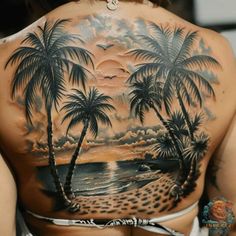 a woman's back with palm trees on the beach