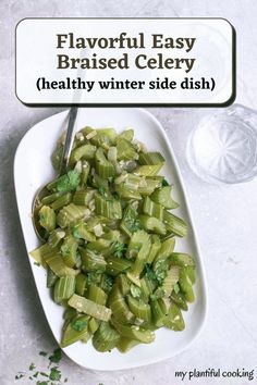 a white plate topped with celery next to a glass of water and a spoon