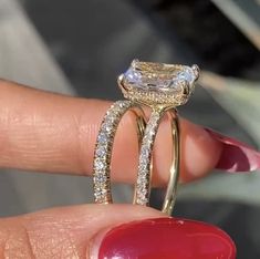 a woman's hand holding an engagement ring with two rows of diamonds on it