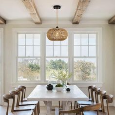 a dining room table with six chairs and a chandelier hanging from the ceiling