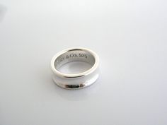 Overview:Offered for sale is a classic and gorgeous Tiffany and Co. Sterling Silver Circle ring.   Looks very feminine and pretty on the fingers, this ring is surely one that you will use over and over again.  It is very versatile, and comfortable to wear.   Easily sizable due to the way it is made.  The ring is currently unengraved on the outside and is ready to be personalized, should you choose to do so.  Great piece to start or add to your Tiffany collection. The ring is fully hallmarked and Tiffany Co Rings, 5 Gifts, Silver Circle, Circle Ring, Gift Love, Tiffany And Co, Ring Band, The Ring, Tiffany & Co.