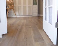 an empty room with white walls and wood flooring on the inside, looking out to the outside