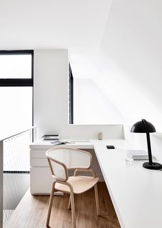 an office with white walls and wooden floors, along with a desk that has a computer on it