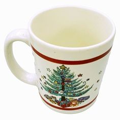 a white coffee cup with a christmas tree on the front and red trimmings