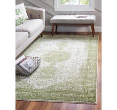 a living room area with a couch, coffee table and rug on the hardwood floor