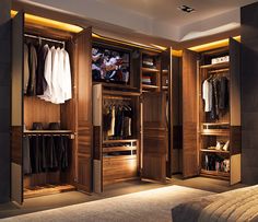 a bedroom with a bed, closets and clothes on display in the middle of it