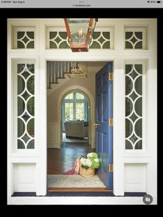 an open door leading to a living room with chandelier hanging from the ceiling