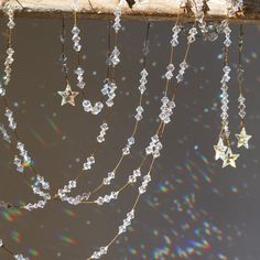 the stars and beads are hanging from the tree branch