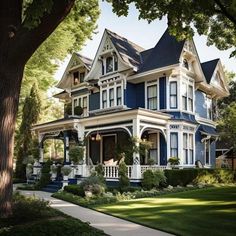 a large blue and white house sitting on the side of a road next to a tree