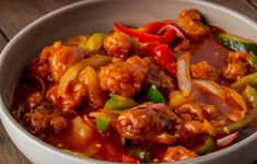 a white bowl filled with meat and vegetables