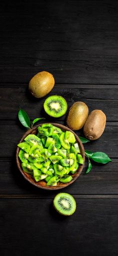 sliced kiwis in a bowl on a wooden table