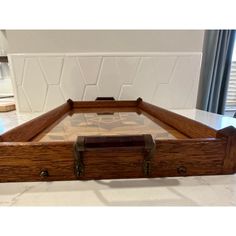 an old wooden box sitting on top of a counter next to a tile backsplash