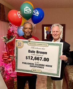 two men standing next to each other holding up a large check for $ 12, 667 00