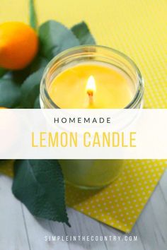 a lemon candle sitting on top of a table next to an orange and green leaf