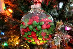 a glass ornament filled with candy on top of a christmas tree