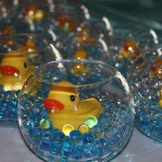 several clear bowls filled with blue beads and yellow rubber ducky toy in it's center