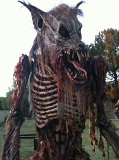 a man dressed as a zombie standing in the grass