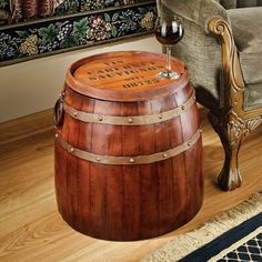 a wooden barrel with a wine glass sitting on top of it next to a chair