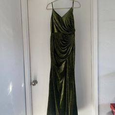 a green dress hanging on a white door