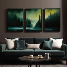 three paintings hang on the wall above a couch in a living room with two coffee tables