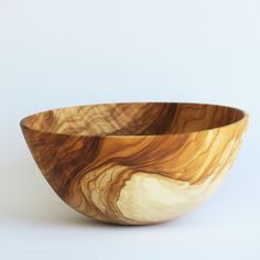 a wooden bowl sitting on top of a white table