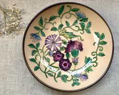 a plate with purple flowers painted on it