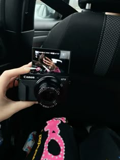 a person is holding up a camera in the car