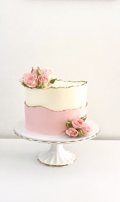 a white cake with pink frosting and flowers on top