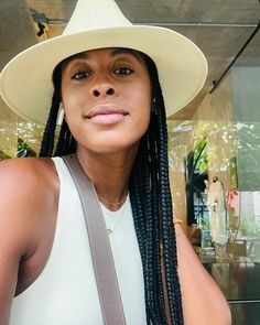 a woman with braids wearing a white hat