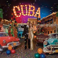 a man and woman standing in front of an old car with the word cuba on it