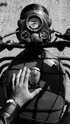 black and white photograph of person on motorcycle with gauges in the back tire area