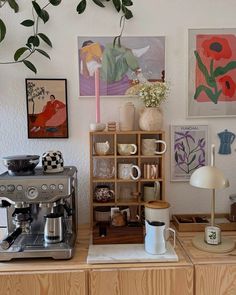 a coffee maker sitting on top of a counter next to a shelf filled with cups and saucers