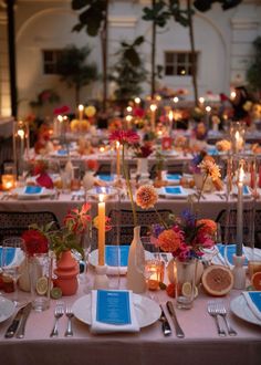 a table set up with plates, silverware and candles