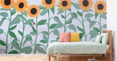 a sunflower wall mural in a child's room with a bed and toys on the floor