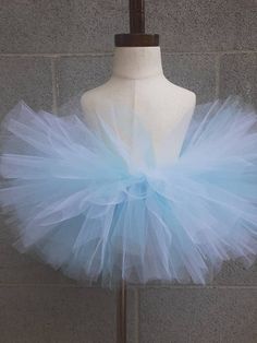 Sparkle, shimmer, twirl and spin,This tutu's where the fun begins,For dress up, play, or just because,All for the little girl you love.This tutu is made with Light Blue and White tulle.Our tutu band's are made from a crocheted material. They are quite stretchy and will fit from newborn up to a 24" waist.To measure start at the belly button and go around the waist.You may choose from 6" length to 13" length. The shorter the length the fluffier it will be.  Here are the lengths we would suggest fo Fitted Glitter Tulle Tutu Dress For Summer, Whimsical Tulle Skirt Tutu Dress For Dress-up, Cute White Tulle Fairy Dress, Summer Princess Tutu Dress In Glitter Tulle, Summer Princess Style Tutu Dress In Glitter Tulle, Fairy Style Summer Tutu Dress, Cute Blue Tutu Dress For First Birthday, Princess Tulle Tutu Dress For First Birthday, Princess Style Tulle Tutu Dress For First Birthday