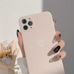 a woman's hand holding an iphone case with heart stickers on it