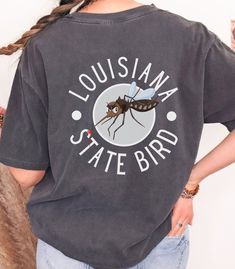 Louisiana State Bird Mosquito T-Shirt Adult Unisex Funny Tshirt Funny Gifts Introducing our humorous Louisiana "State Bird" Mosquito t-shirt! Embrace our beloved state of Louisiana with this tongue-in-cheek design featuring a shifty-eyed sneaky mosquito. It's a lighthearted nod to the state's unofficial winged companion that never fails to make an appearance, many times bringing several friends along. Crafted for comfort and durability, this tee brings together humor and style. Wear it, laugh, a Funny Mosquito, Inside Joke, State Birds, Louisiana State, Funny Tshirt, Tshirt Funny, Inside Jokes, Dye T Shirt, Computer Monitor